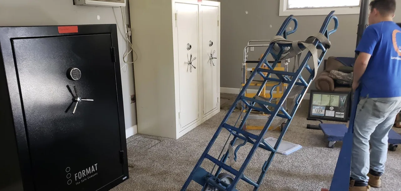 A large safe beside handling equipment in a garage
